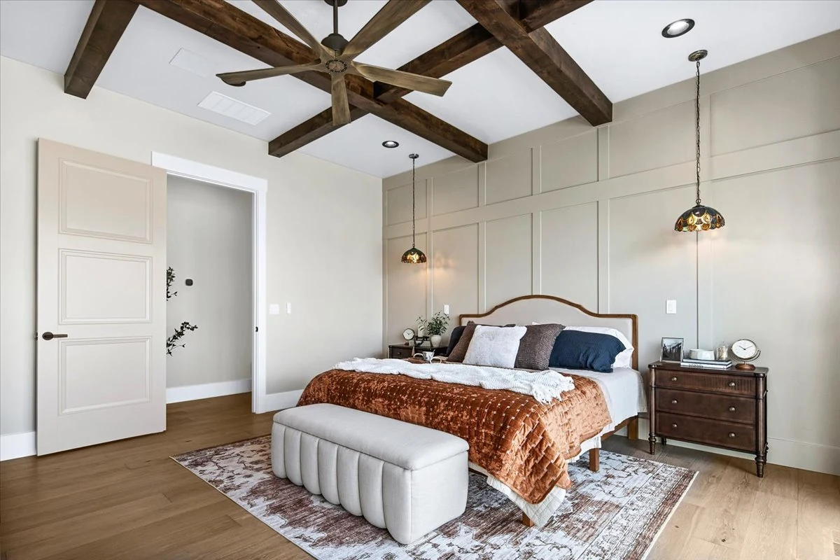 Bedroom with timber ceiling beams and an upholstered bed