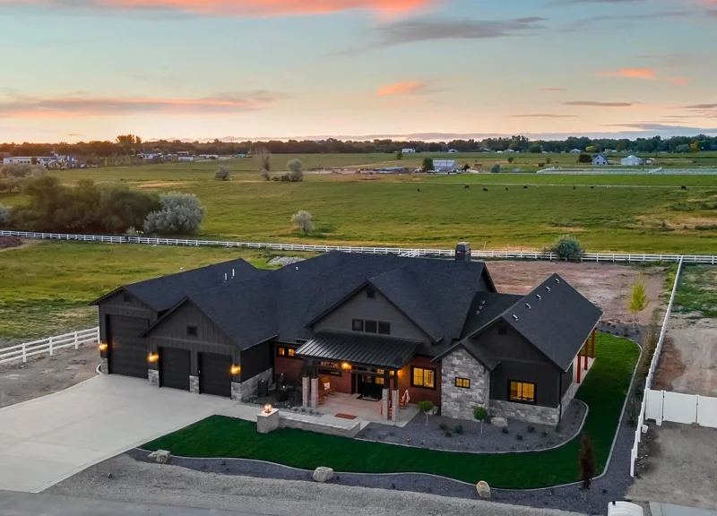 Front Exterior of the Welles by Bachman Custom Homes with a sunset sky and open fields in the distance